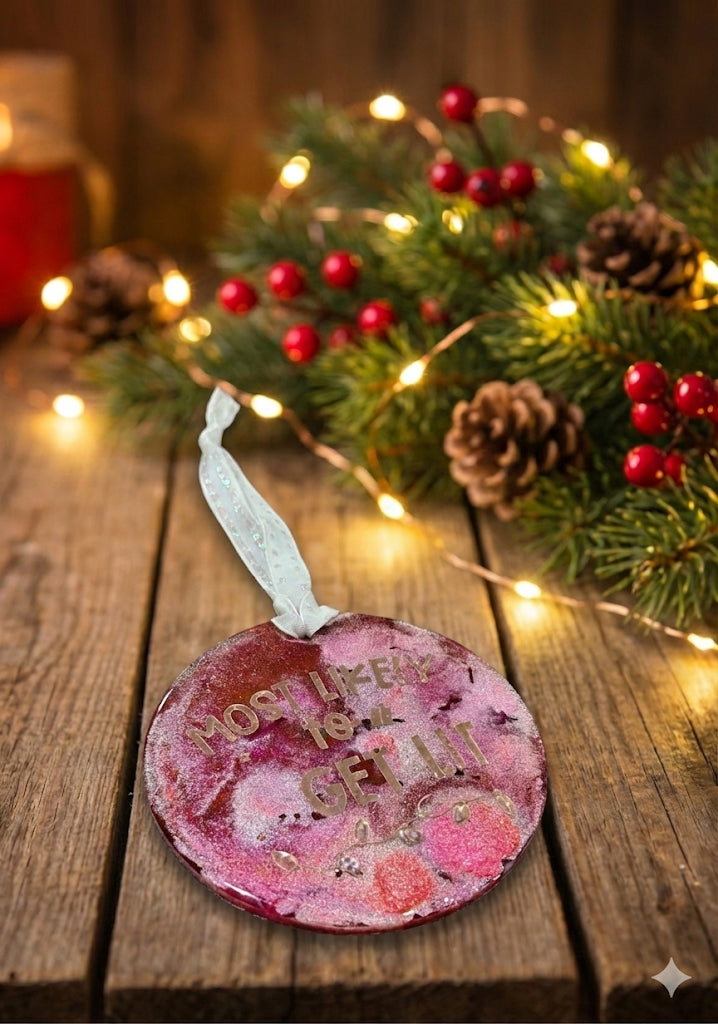 Decorative ornament with text on a wooden surface with Christmas decorations.