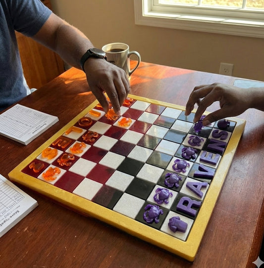 Two people playing a board game on a wooden table with a cup of coffee.